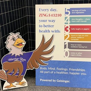 Warrior Run mascot cutout with Zing poster